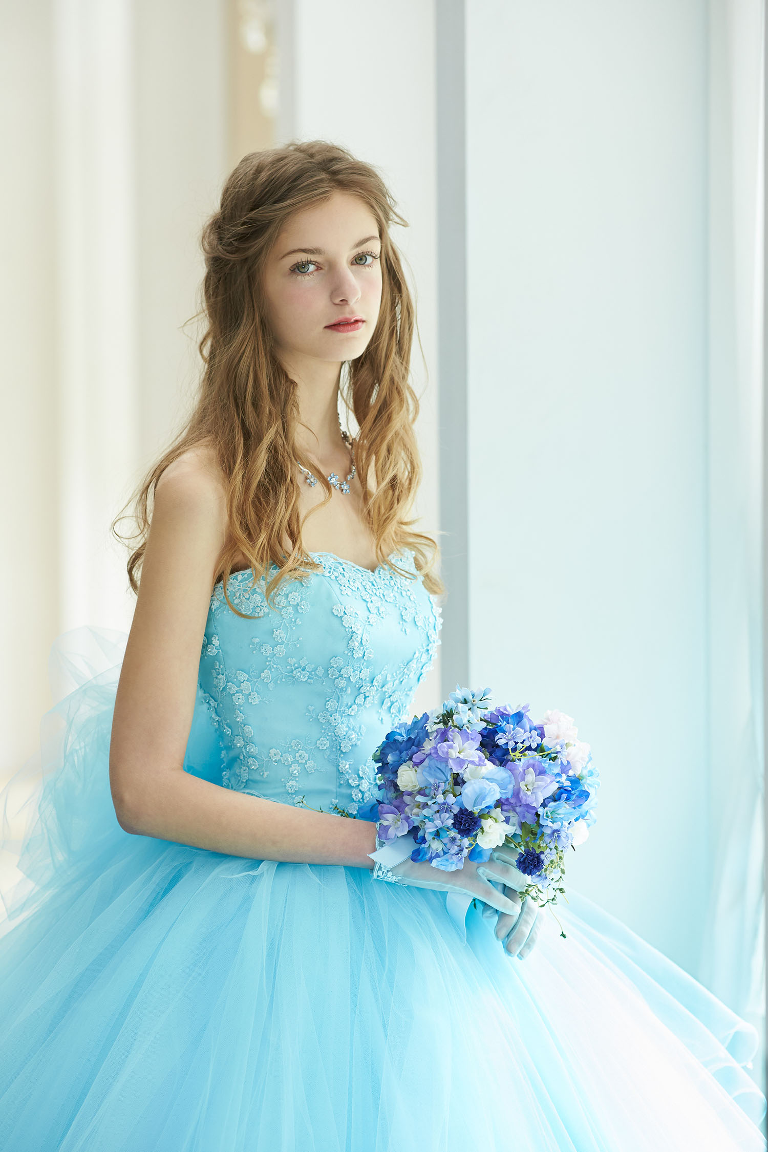 淡く重なり合うブルーのチュールが風になびく美しいカラードレス